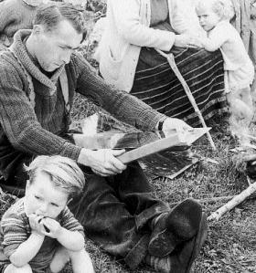 Tinsmith Bernard Mongan making a tin can at a Traveller encampment, Cahermorris, Co. Galway, c. 1960s. Note the uniquely Traveller apron worn by the woman on the right. (National Museum of Ireland)