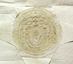 Ó Maolchonaire’s crest: the Red Hand, surrounded by a flowing material known as mantling, appears below a flat, wide-brimmed episcopal hat, flanked by rows of tassels on each side. The archbishop’s cross appears between the hat and the Red Hand, denoting his metropolitan jurisdiction as primate of Connacht. Although only the beginning and end of the inscription (top right and top left respectively) are visible in this particular reproduction, the edge of the seal is inscribed with Ó Maolchonaire’s name and title in Latin: Florentius Conrius Archiepiscopus Tuamensis. (Archivo General de Simancas)