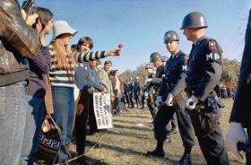 A female demonstrator offers a flower to military police on guard at the Pentagon during an anti-Vietnam demonstration on 21 October 1967. (National Archives, USA)