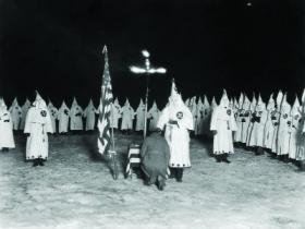 Ku Klux Klan initiation ceremony, 1920s—Coyle openly denounced it as ‘un-American’, and became a figure of hate. (Jack Benton—Hulton Archive/Getty Images)