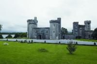 The front of Lough Cutra Castle, a series of Gothic towers attached to one another by castellated sections. The tower to the right, at the south-west corner, looks more striking