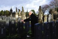 A participant touches one of the 43 headstones of Irish servicemen and women from both world wars dedicated at an ecumenical ceremony held in Glasnevin Cemetery on 11 November 2010—one of the final set of images in David O’Flynn’s e-book.