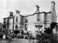 The gutted ruins of the parochial house following attacks on Catholic-owned property in Lisburn in August 1920. A disturbing feature is that the crowd in front (including women and children) is a loyalist one (note the Union Jack) clearly proud of its handiwork in the cold light of day. (Mooney Collection)