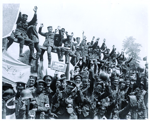 Men from the Royal Inniskilling Fusiliers and Royal Irish Rifles celebrating their victory at Wijtschate, June 1917. Note the YCV flag (Young Citizen Volunteers, youth section of the Ulster Volunteer Force). (Imperial War Museum)