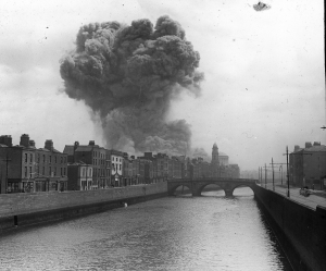 The Four Courts on the afternoon of 30 June 1922, when the Record Treasury at the Public Record Office exploded, sending up a mushroom cloud—and countless priceless official documents. One of the anti-Treaty IRA garrison was the author’s great-uncle, Ned Horan (below), seen here in the turret of the commandeered armoured car, The Mutineer. Tom Barry has his leg astride the spare wheel. (South Dublin Libraries)