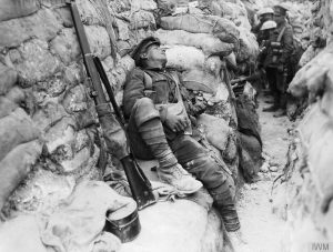 Above: An exhausted soldier asleep in a front-line trench at Thiepval, September 1916. (IWM)