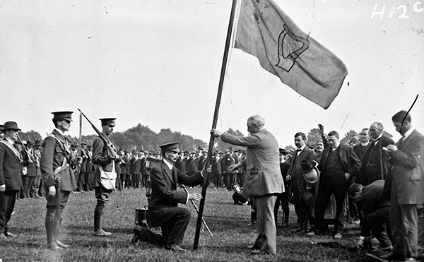 Above: John Redmond presenting a regimental flag bearing a harp to a unit of the National Volunteers in the Phoenix Park in April 1915. (NLI) 